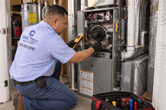 Technician inspecting a gas furnace in a Dallas area home during winter